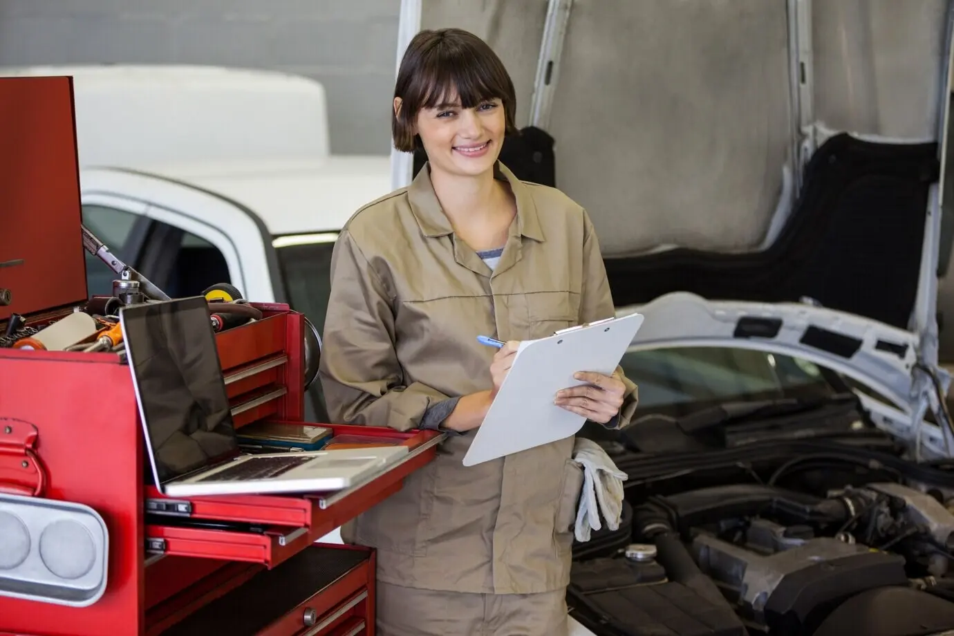 Porträt einer Mechanikerin, die eine Checkliste vorbereitet.