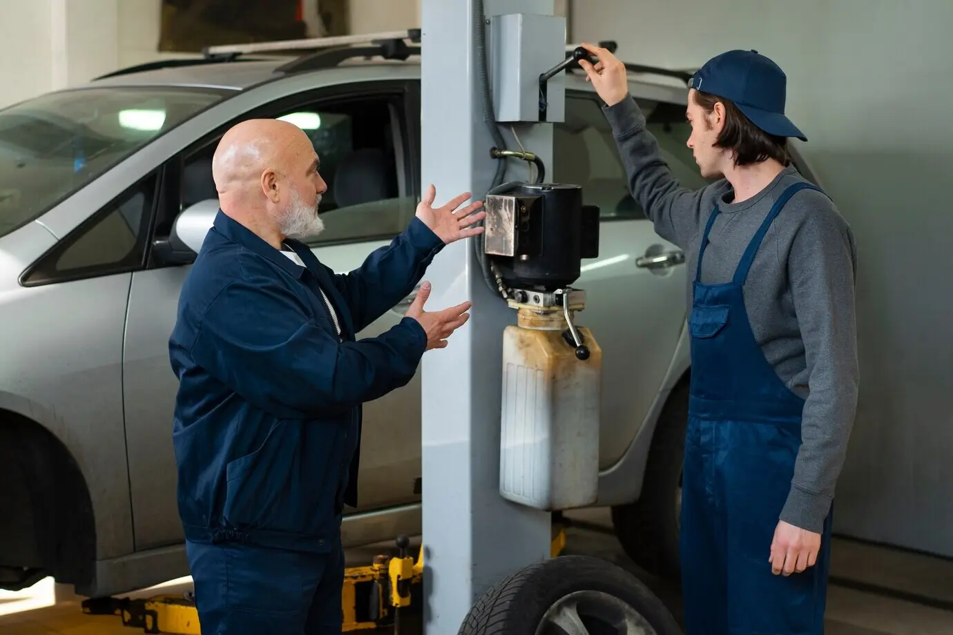 Männlicher Kfz-Mechaniker bei der Arbeit in der Autowerkstatt.