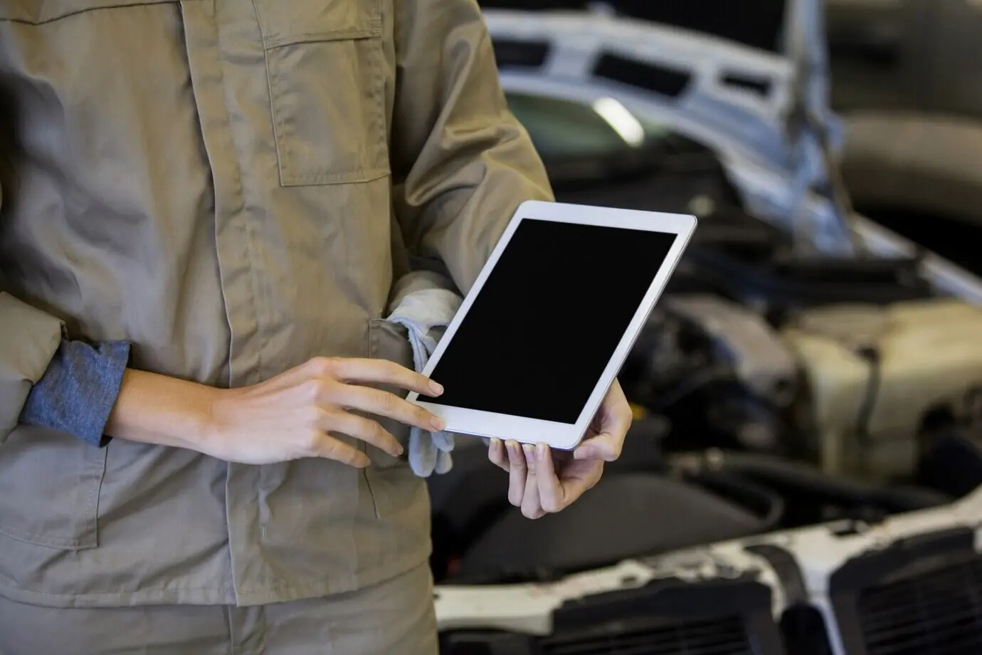 Ein Mechaniker nutzt ein digitales Tablet in der Werkstatt.