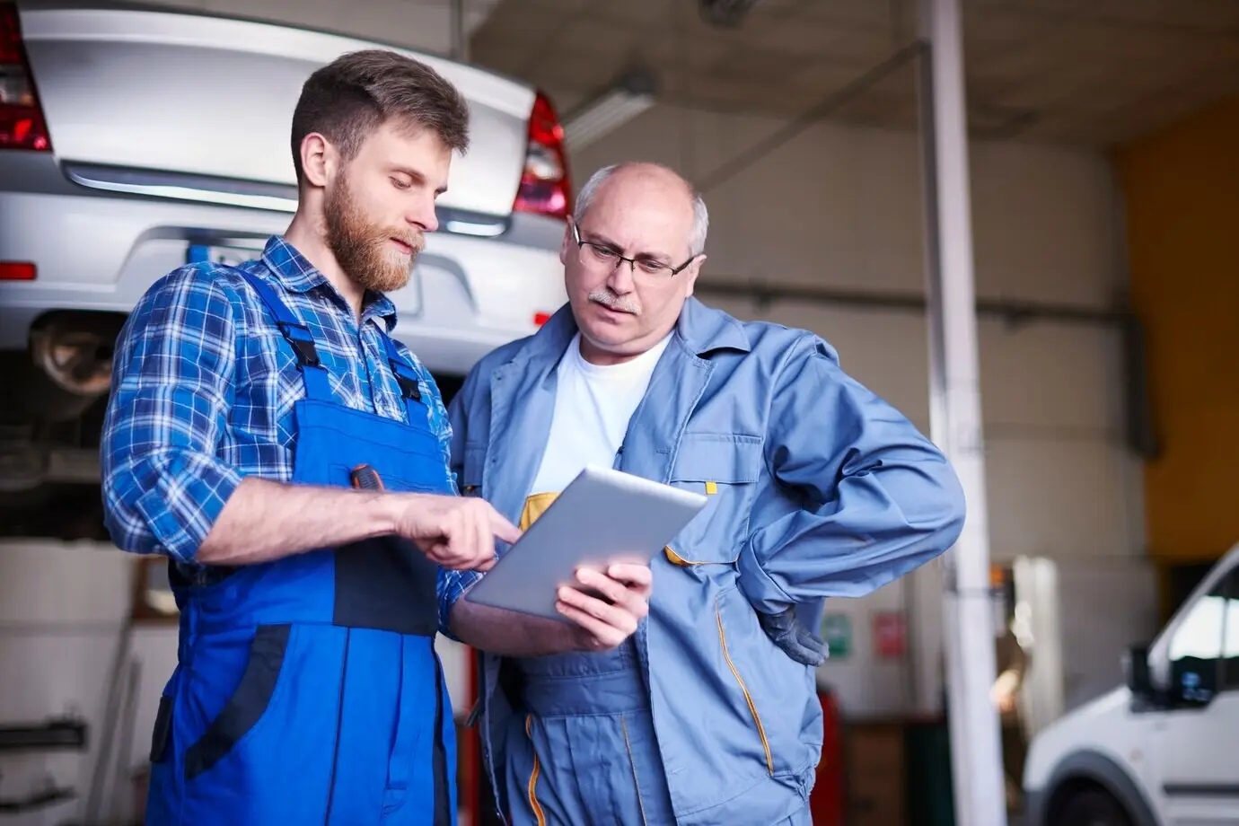 In der Werkstatt reparieren Mechaniker ein Auto.