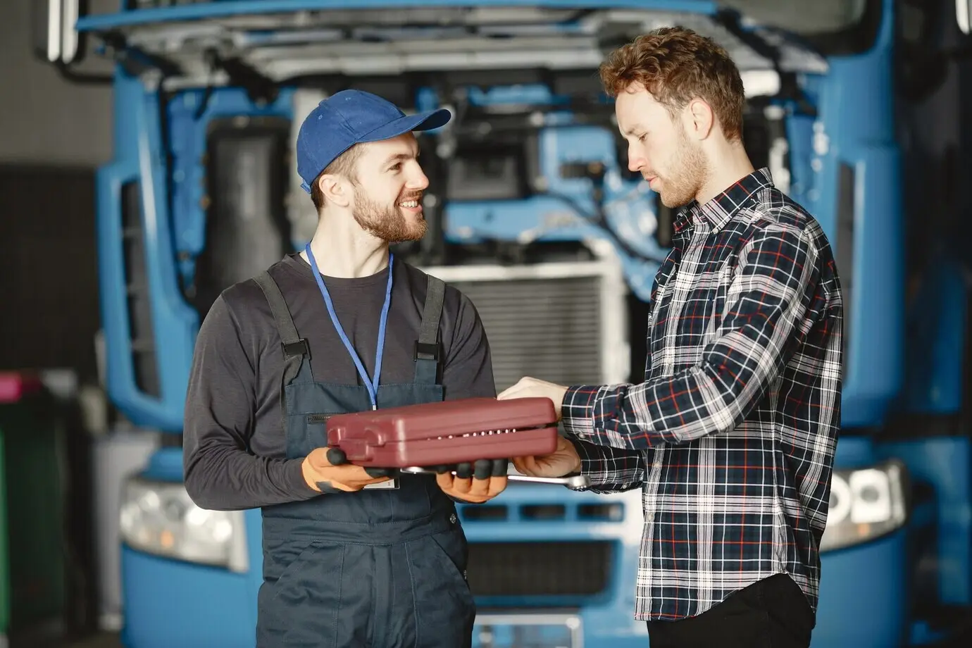 Zwei uniformierte Arbeiter mit Werkzeugen an einem Arbeitstag.